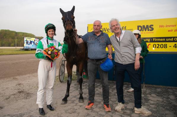 Foto &copy; GelsenTrabPark &ndash; NINA BALTROMEI stellte eindrucksvoll unter Beweis, dass ihr K&ouml;nnen keine Grenzen kennt: Nicht nur im Galoppsport wei&szlig; sie zu &uuml;berzeugen, auch bei den Trabern stellt sie sich direkt erfolgreich vor.  Am Kopf des siegreichen Gespanns pr&auml;sentierten sich stolz Besitzer MARCEL MATTEN sowie Rennbahnpr&auml;sident UWE K&Uuml;STER.